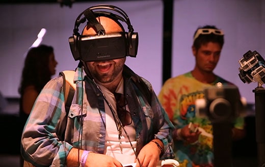 a man at a conference laughing while wearing a virtual reality headset